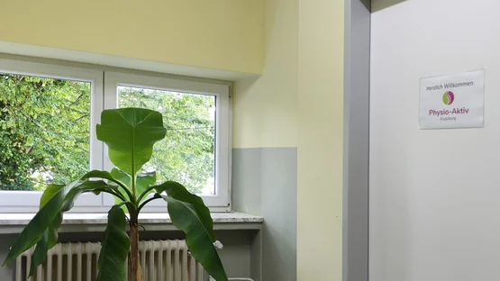 Eingangsbereich mit Begrüßungsschild von Physio-Aktiv Augsburg